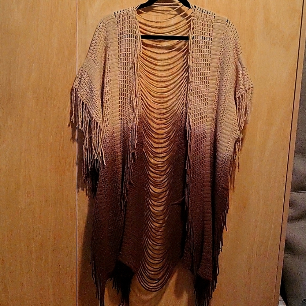 Knitted ponch style vest. Fringe and super cute detail on back.